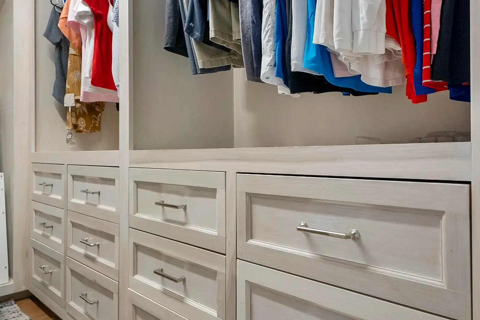 Elegant custom closet with open shelving, ample hanging space, and a modern wood finish.
