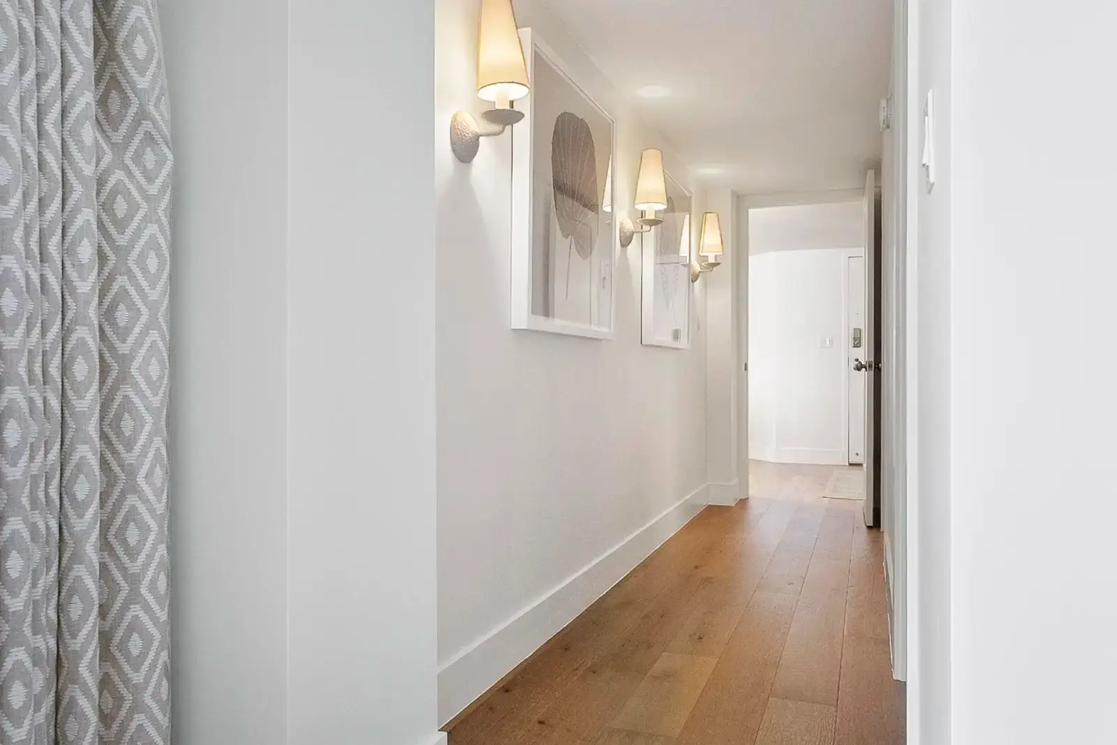 A well-lit hallway with elegant flooring and clean lines.
