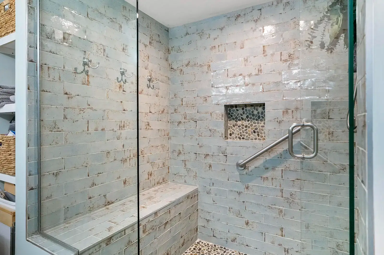 A spacious shower with modern tiling and glass enclosure.